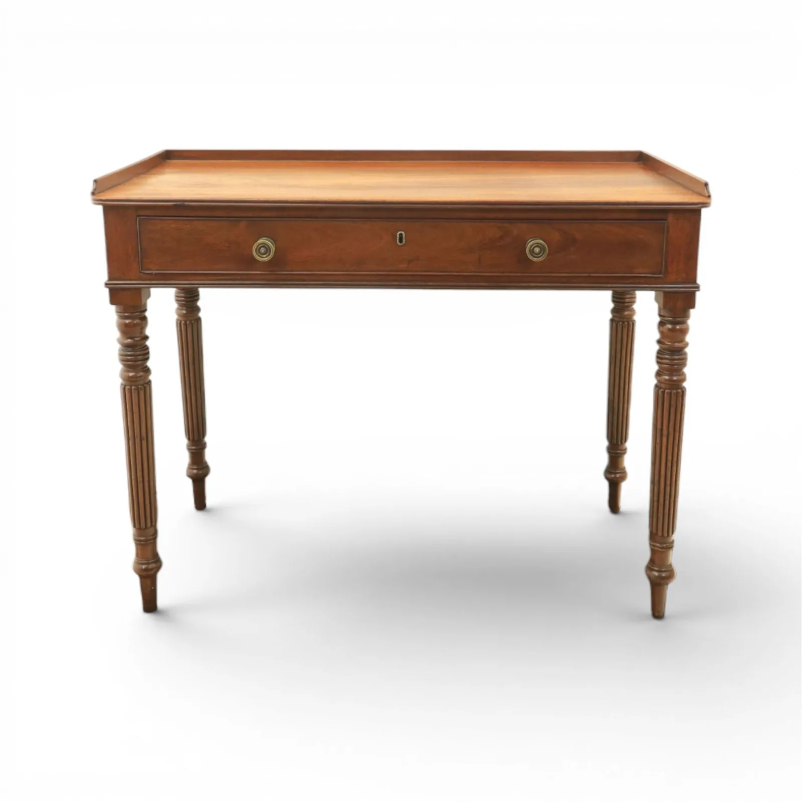 Regency English mahogany dressing table, stamped Gillow, early 19th century; rectangular top with three-quarter gallery above a frieze drawer with twin brass knobs; raised on turned and reeded supports