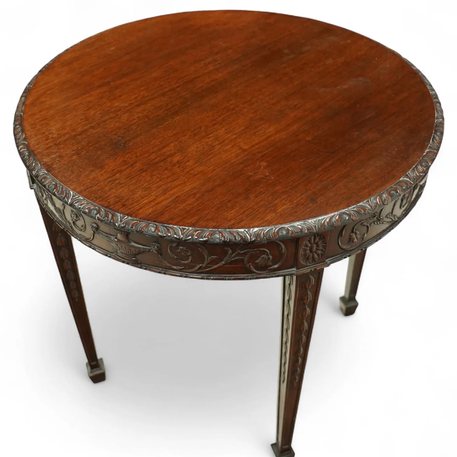 Early 20th-century Adam style mahogany circular centre table; moulded frieze carved with scrolling foliage, urns and rosettes; square tapering legs with husk carving, terminating in spade feet thumbnail 4