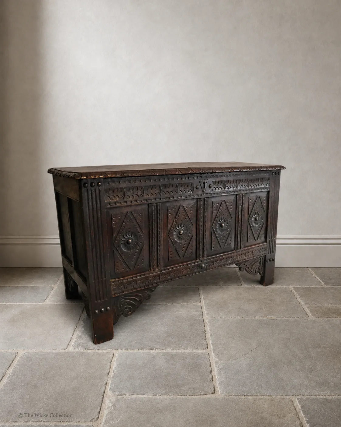 19th-century carved oak coffer; rectangular plank top over a four-panel front with lozenge and flowerhead carving, shaped lower apron, stile feet; sturdy provincial work thumbnail 2