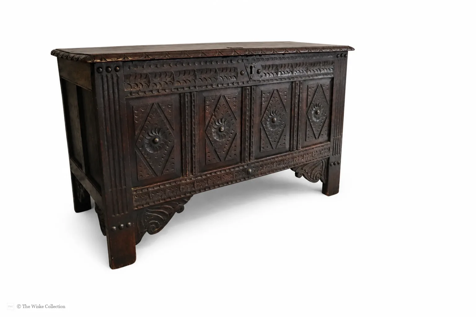 19th-century carved oak coffer; rectangular plank top over a four-panel front with lozenge and flowerhead carving, shaped lower apron, stile feet; sturdy provincial work