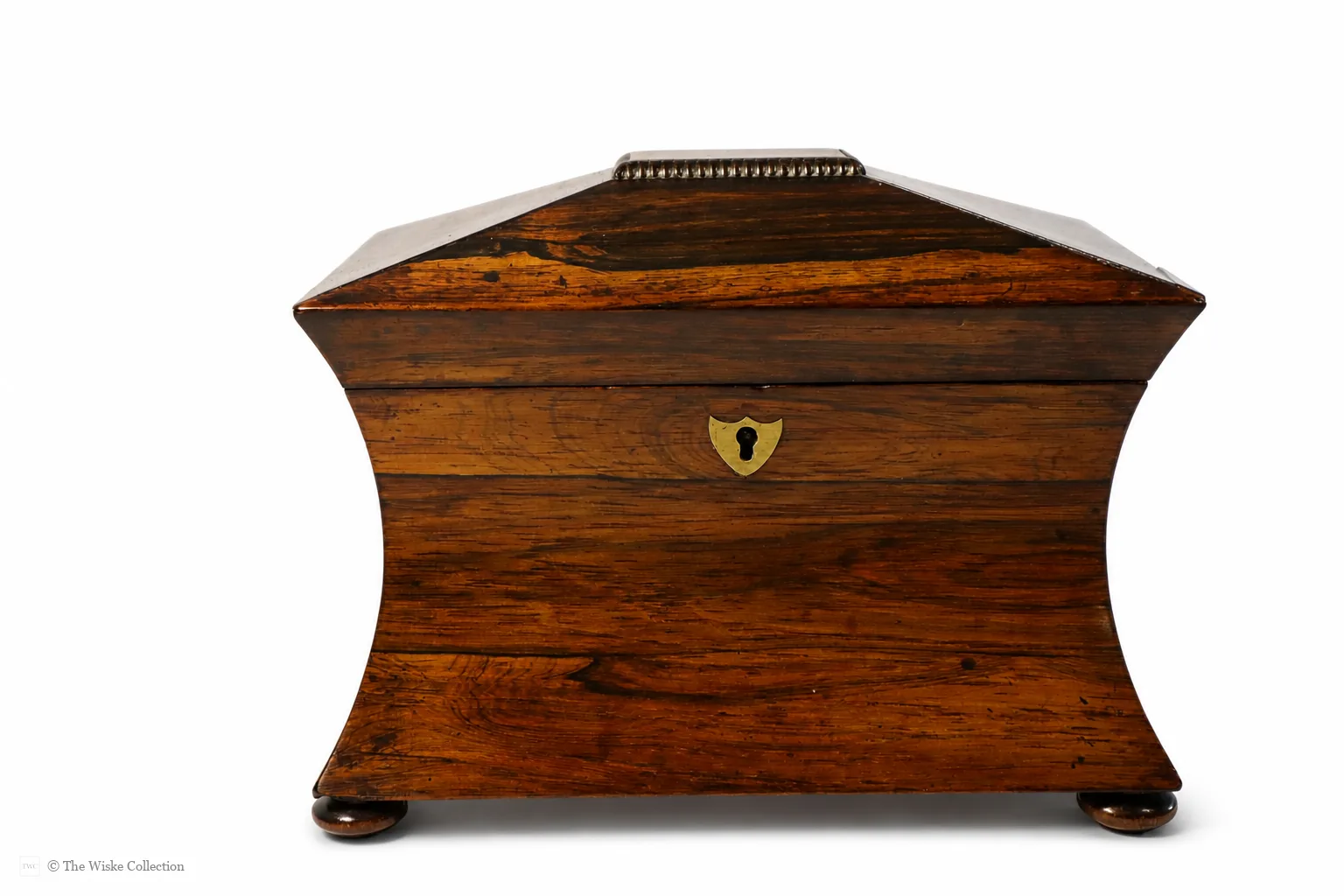 Early 19th-century rosewood tea caddy of waisted sarcophagus form, with twin compartments, brass keyplate, and compressed bun feet; 17cm high, 22cm wide