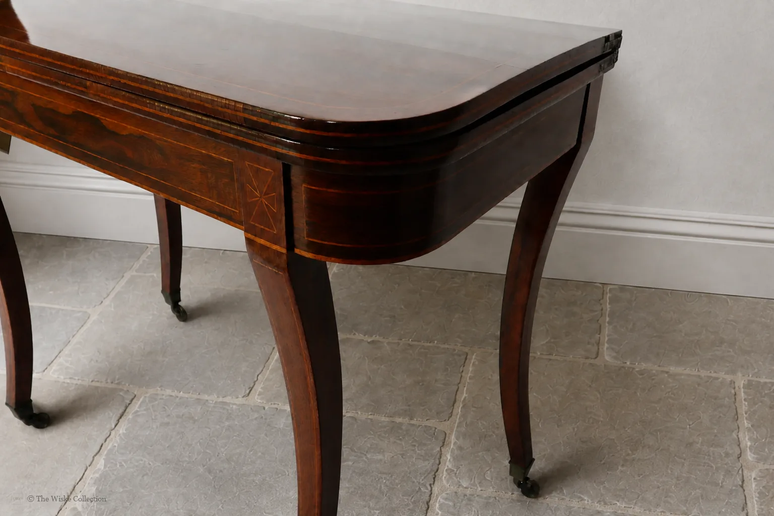 Beautiful Regency rosewood folding tea table, early 19th century, rounded rectangular top with satinwood banding and crossbanded frieze; hinged fold-over action; raised on tapered square supports with brass castors thumbnail 4