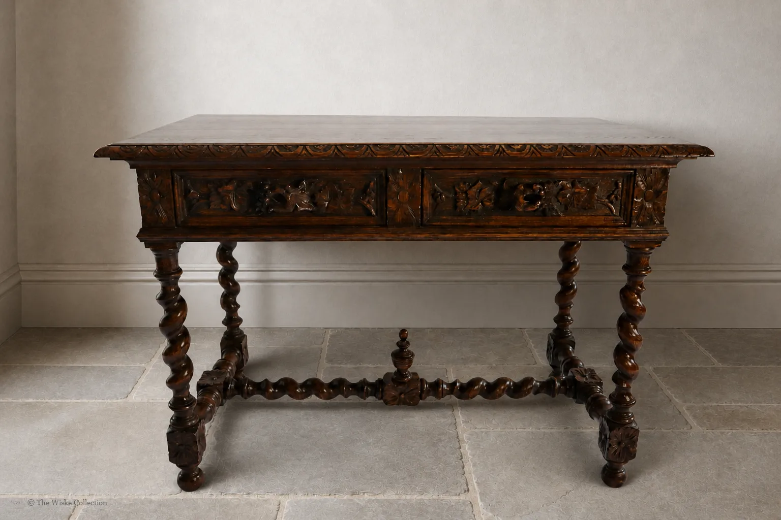 Victorian carved oak side table with solid moulded and carved rectangular top, deep frieze of foliate-carved twin drawers flanking a central panel, on barley-twist legs united by a shaped stretcher with turned knop, ending in block feet